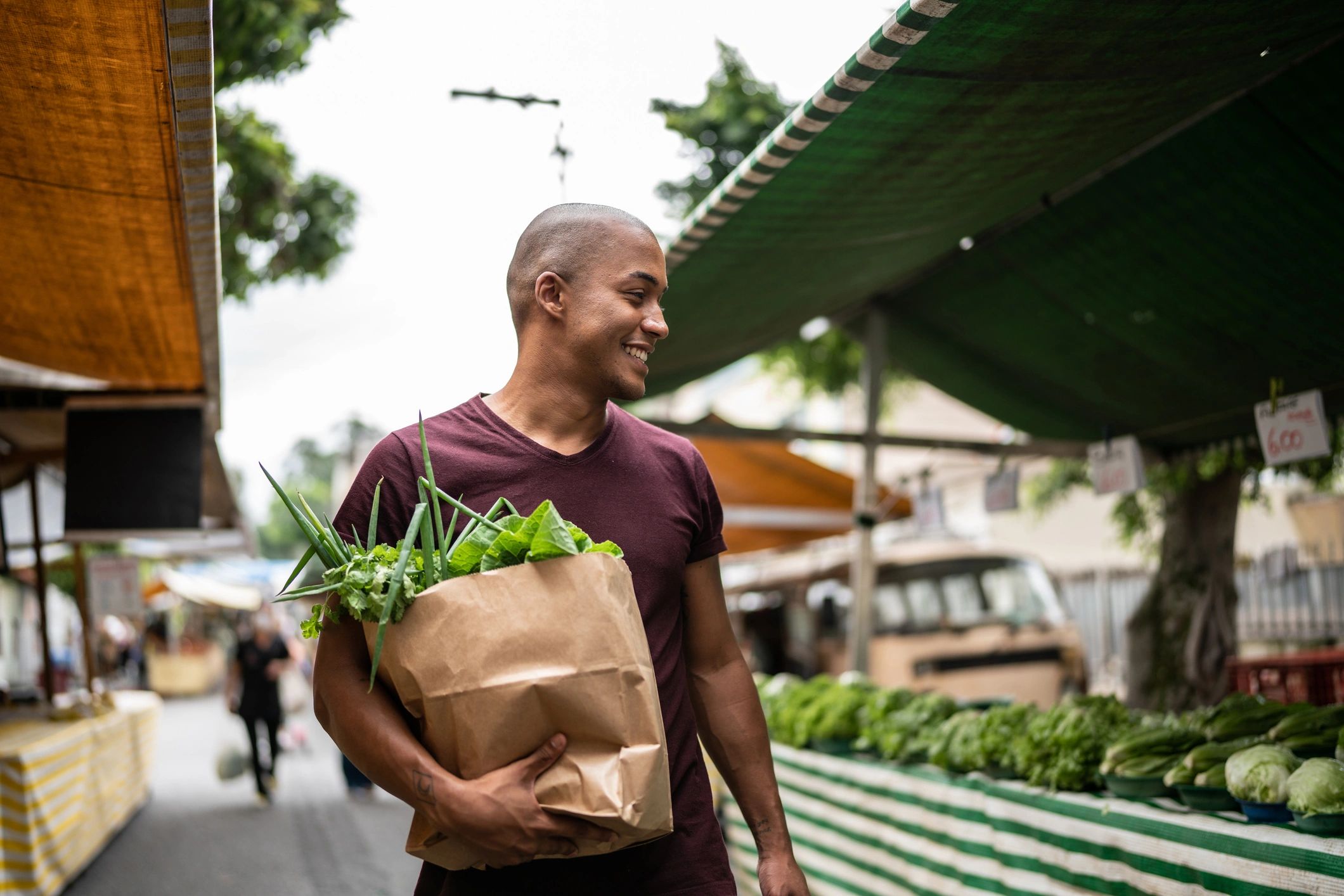 Person carrying groceries at an outdoor market