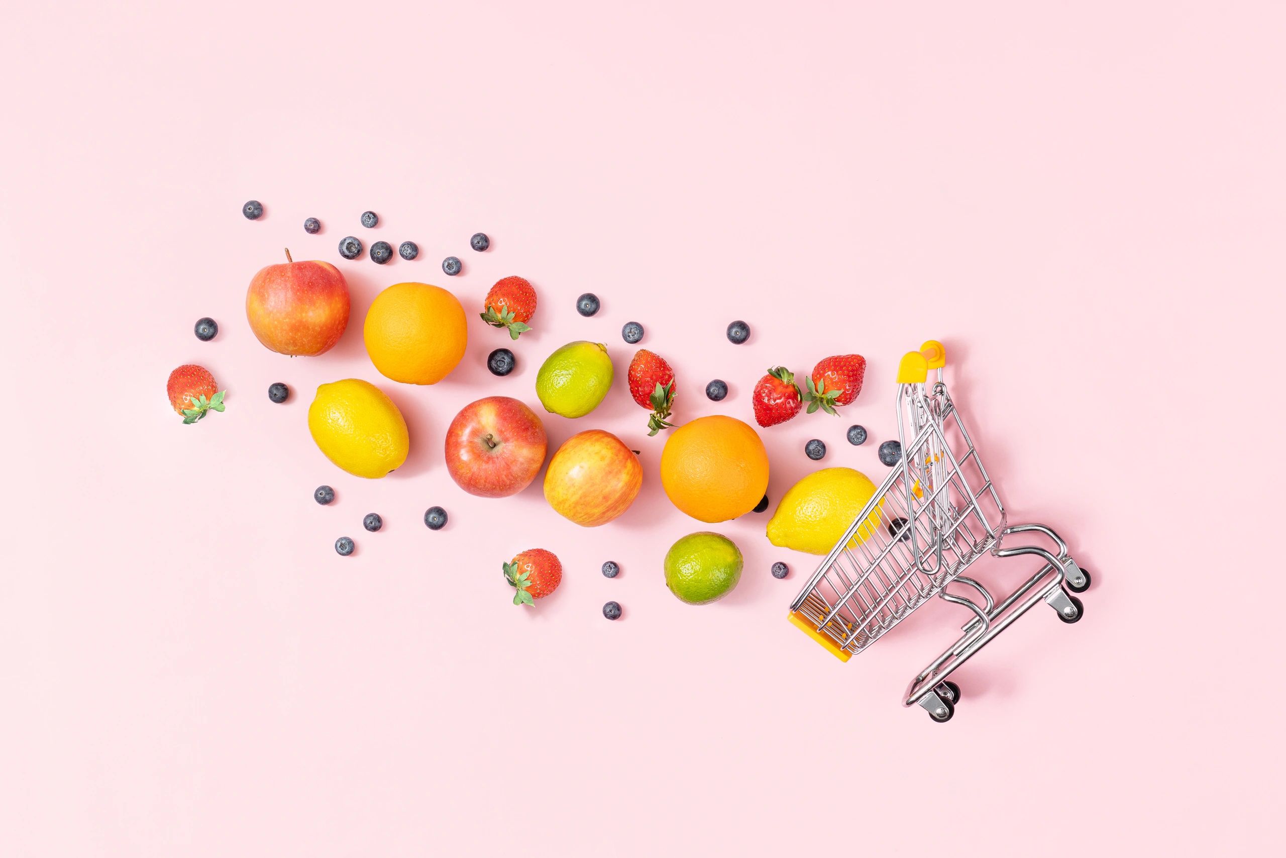Grocery cart with fresh fruit and copy space