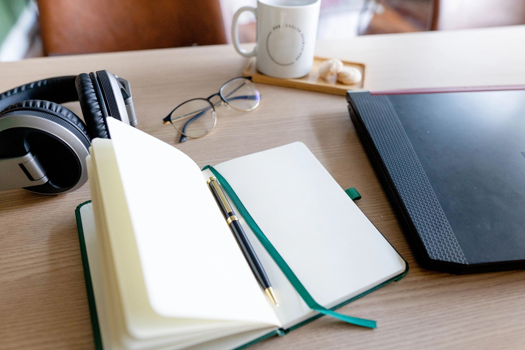 Notebook and laptop on a desk for planning a monthly budget